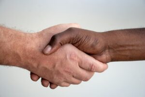 A close up photo of two hands shaking.