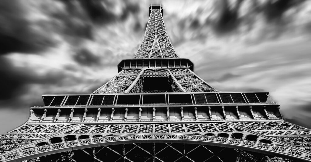 A black and white photo looking up the Eiffel Tower.