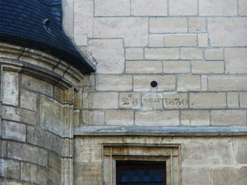 A close up photo of the cannonball buried in the facade of the Hotel de Sens.