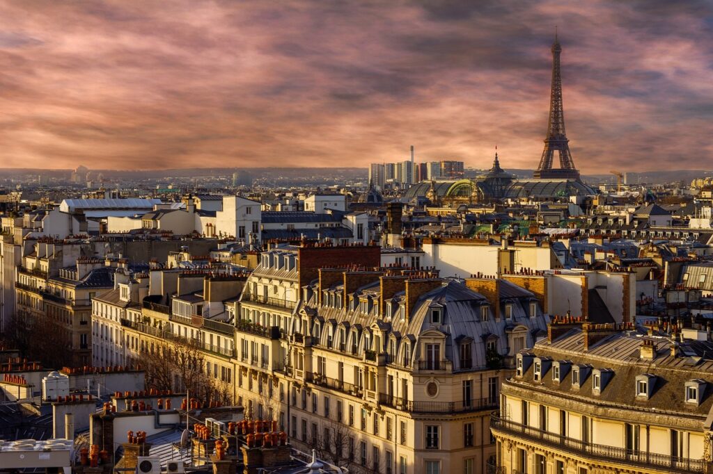 A photo of the Paris skyline at sunrise with the Eiffel Tower in the background.