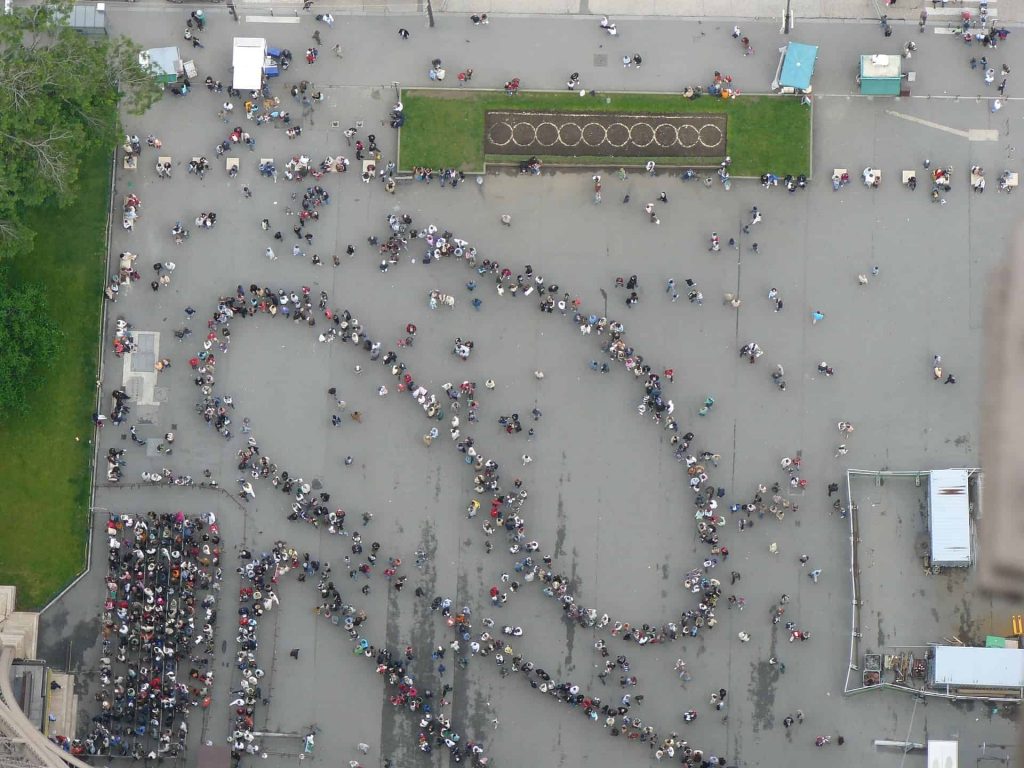 A picture from above of a long line at the Eiffel Tower, one of the places to skip if you want to avoid the crowds in Paris