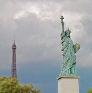 A photo of the statue of liberty with the Eiffel Tower in the background.