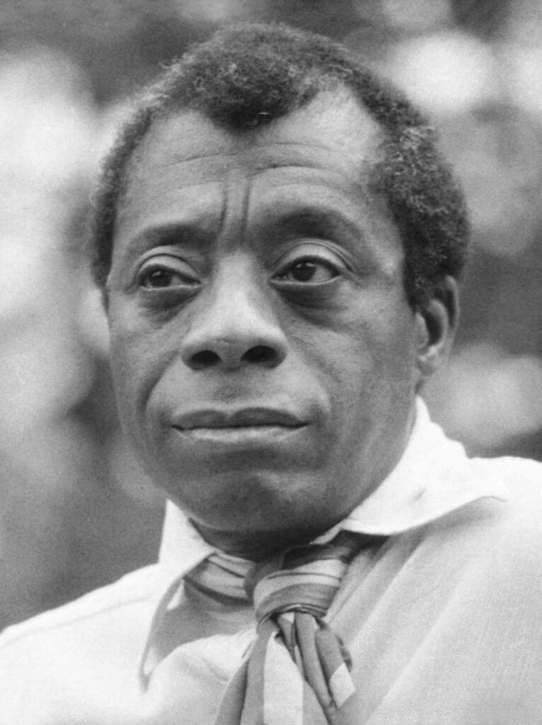 A black and white headshot of James Baldwin looking just off camera.