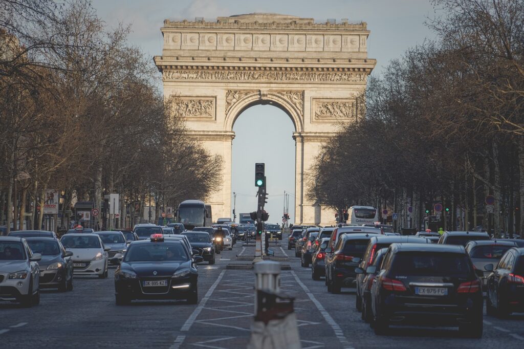 A photo of traffic on the Champ Élysées with the Arc de Triomphe in the background.