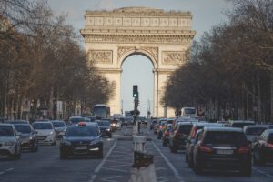 A photo of traffic on the Champ Élysées with the Arc de Triomphe in the background.