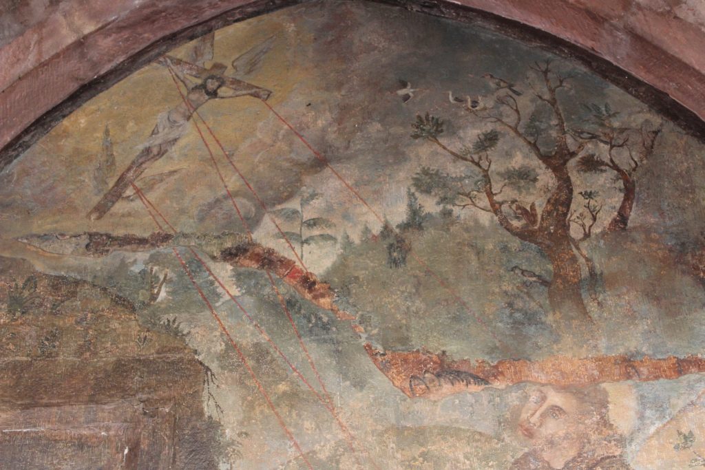 A photo of the mural in the cloisters that depicts a flying Jesus on a cross with what appears to be laser beams shooting out from the nails.