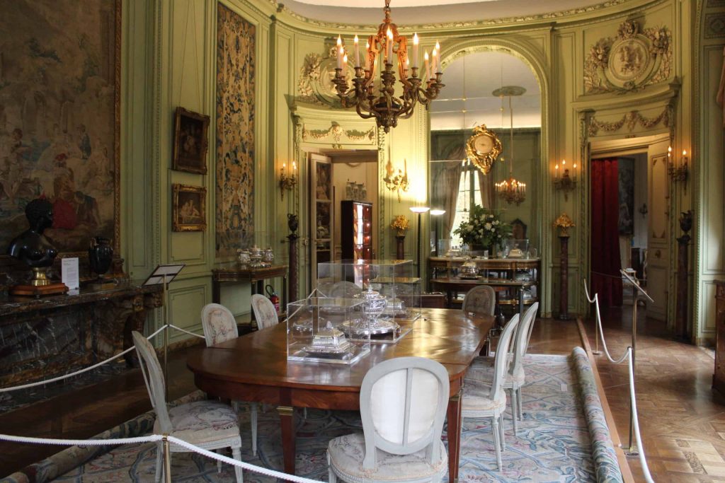 A photo of the dining room with a chandelier hanging above the main table.