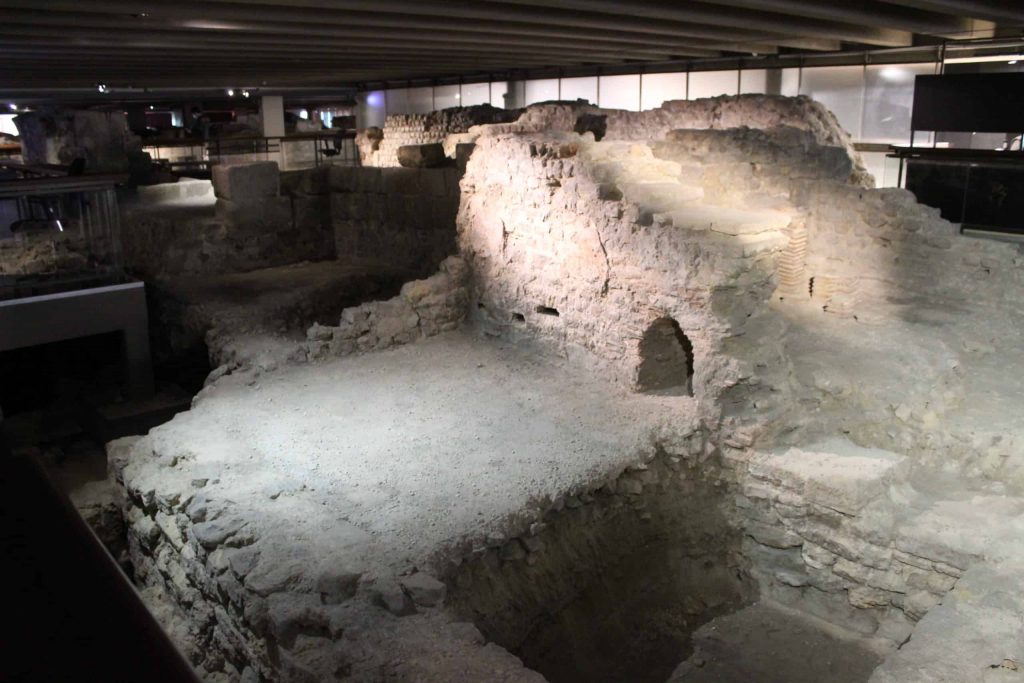 A photo of the ruins in the archeological crypt, including some walls and a small archway.