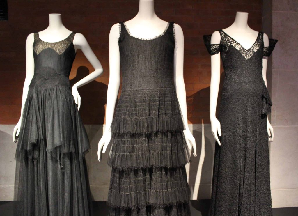 A close up photo of three black dresses displayed at the Palais Galliera as part of the Gabrielle Chanel exhibition.