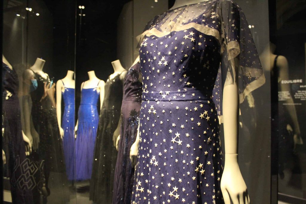 A photo of several blue evening gowns by Chanel, on display at the Palais Galliera.