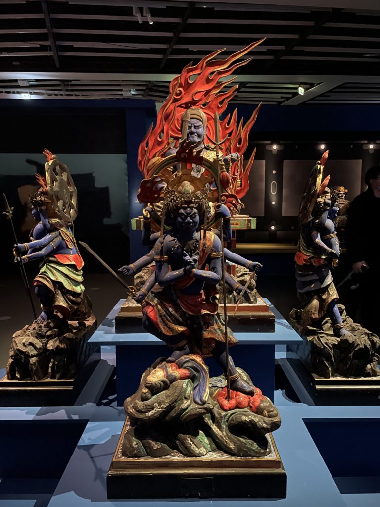 A photo of a display at Ultimate Combat. The display is of several statues depicting gods in the mythology of martial arts.