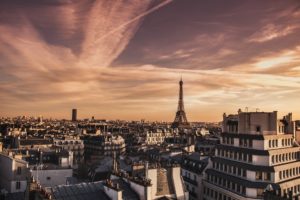 A photo of the cityscape of Paris, at sunset, with the Eiffel Tower in the distance.