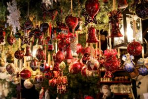 A close up photo of ornaments hanging in a Christmas market