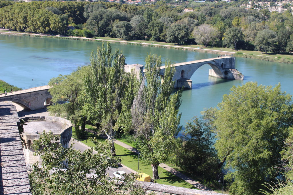 A photo of the Pont d'Avignon, taken from above, looking down as the four arches leading out into the Rhone river.