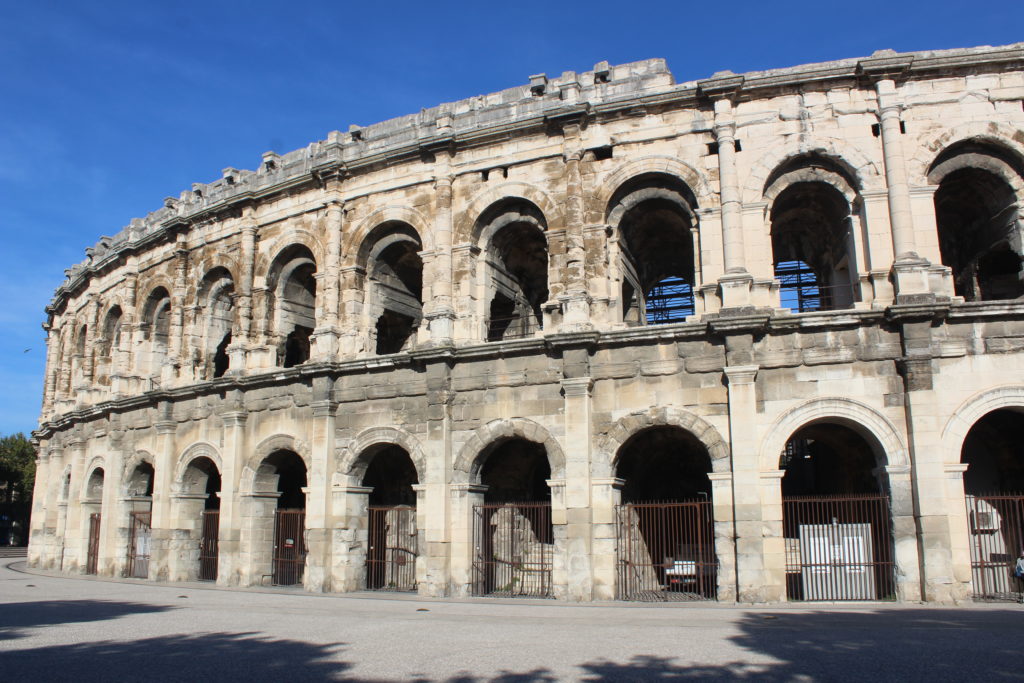 A photo of the exterior facade of the Roman amphitheatre in Nîmes.