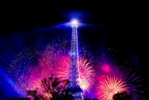 A photo of the Eiffel Tower illuminated by fireworks.