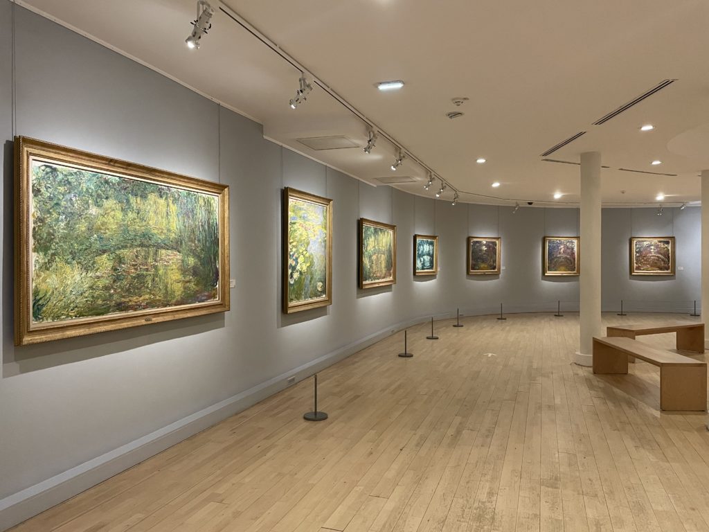 A photo of a gallery inside the Musee Marmottan Monet. It shows a wall full of Impressionist paintings.