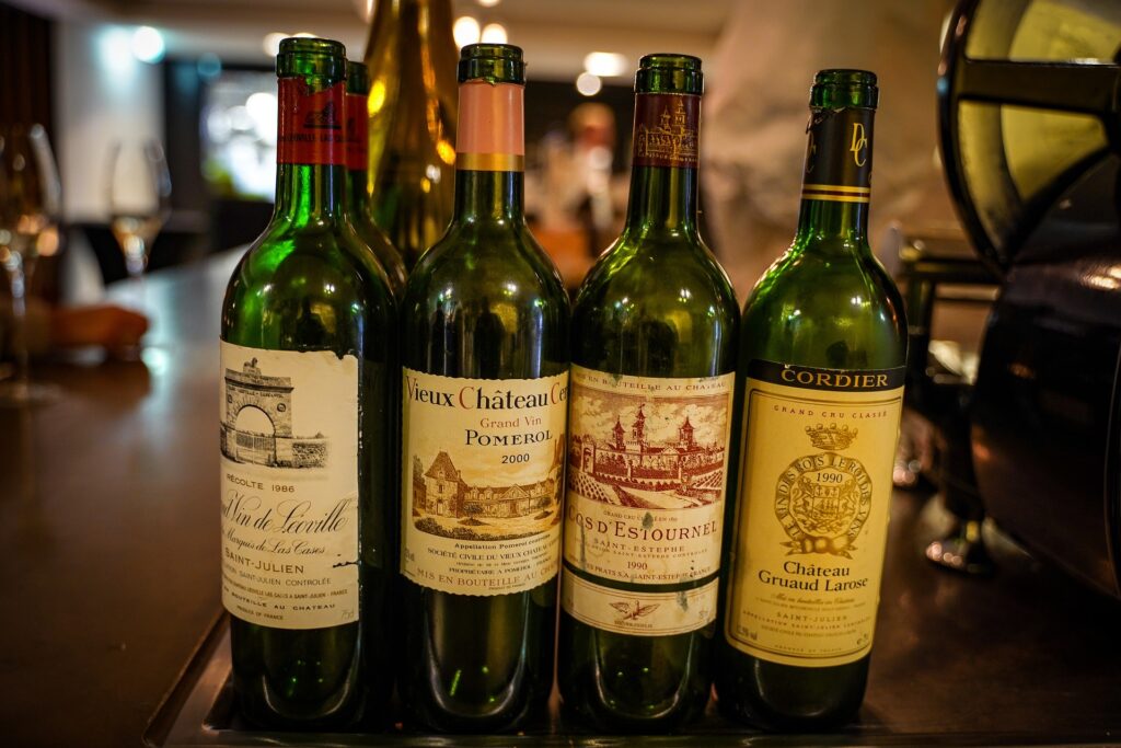 A photo of four wine bottles in a row on a counter in a restaurant.