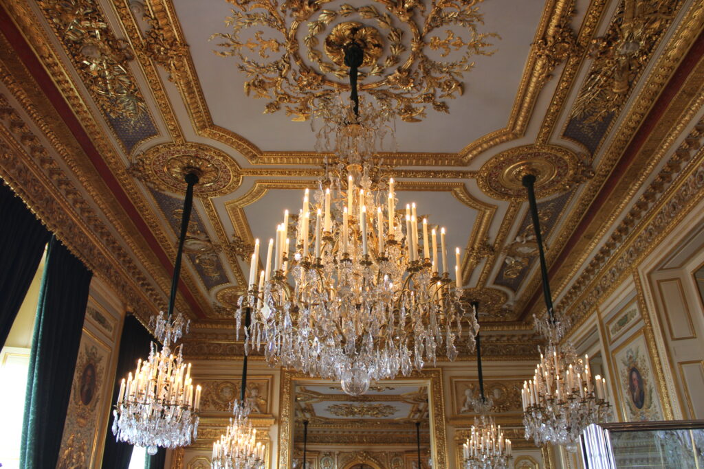 A photo of the interior of the Hôtel de la Marine. It shows a gilded room with chandeliers hanging from the ceiling.